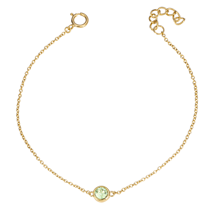 Gold bracelet with a green gemstone on a white background
