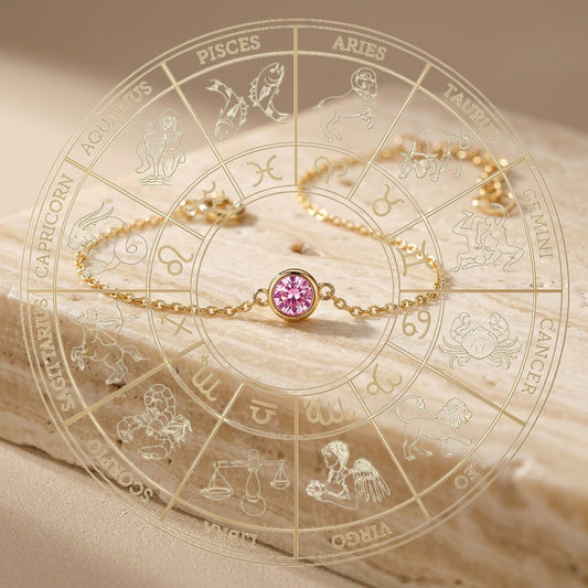Gold bracelet with a pink gemstone on an astrological chart