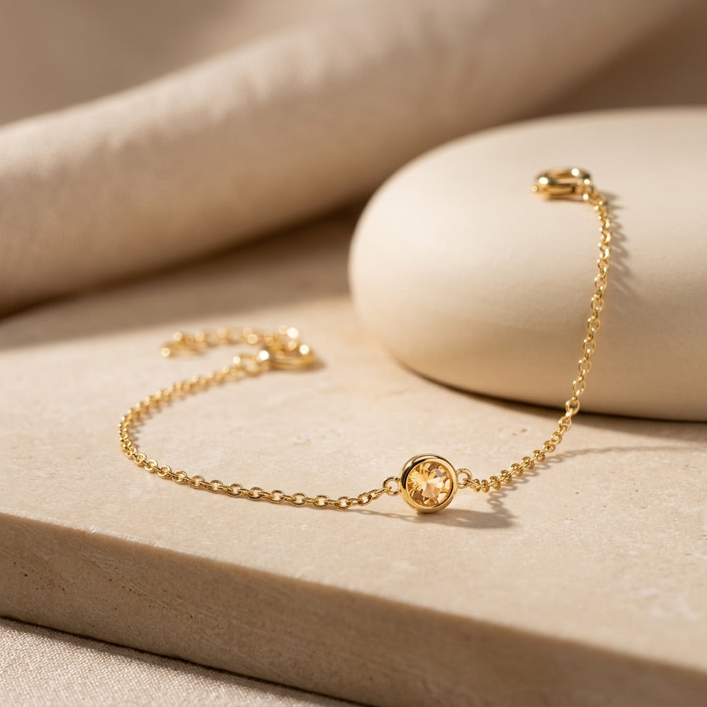 Gold bracelet on a beige stone surface
