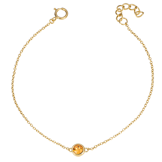 Gold bracelet with a round gemstone on a white background