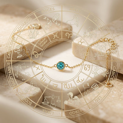 Gold bracelet with a blue gemstone on an astrological wheel background