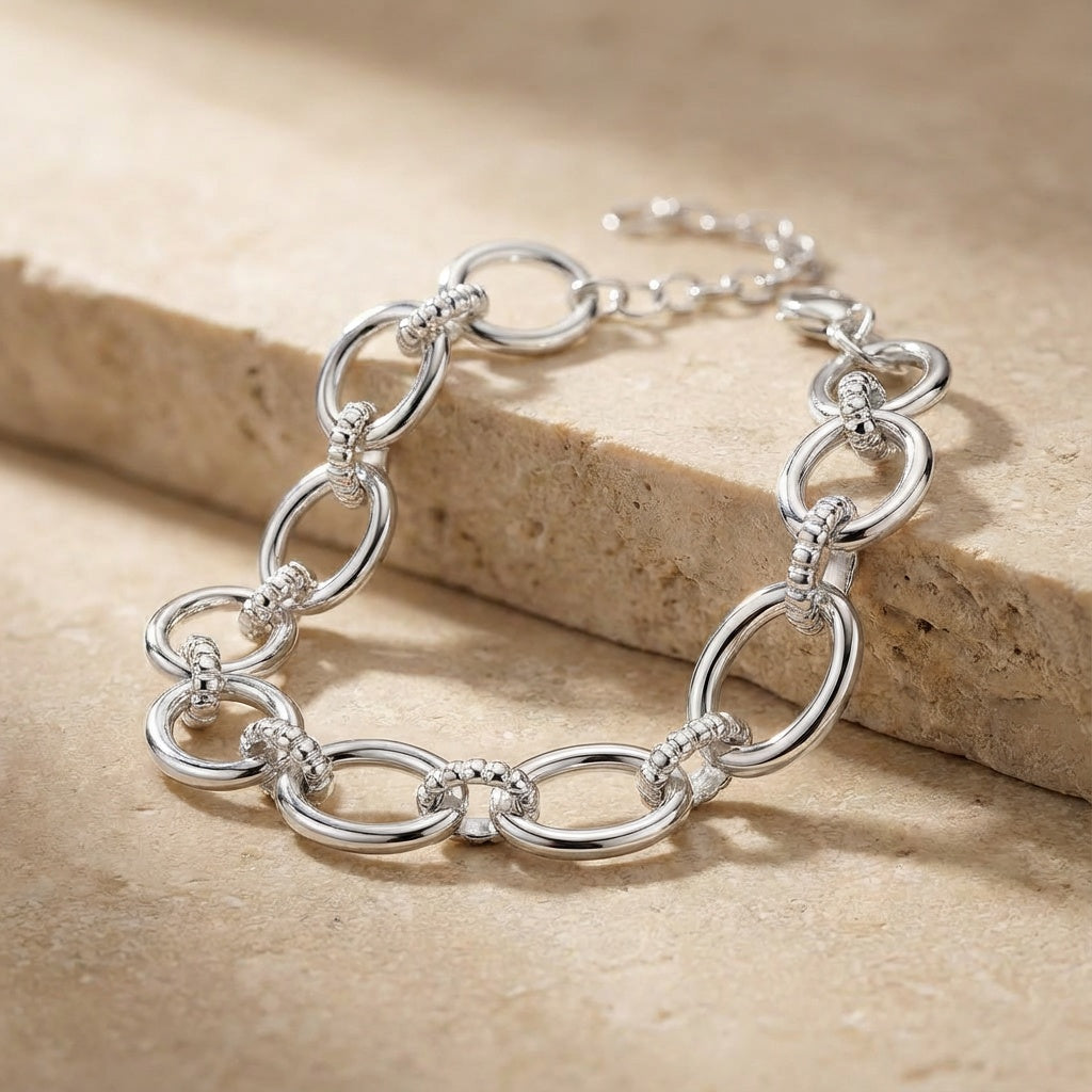 Silver bracelet on a beige stone surface