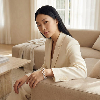 Woman in a beige suit sitting on a couch in a well-lit room