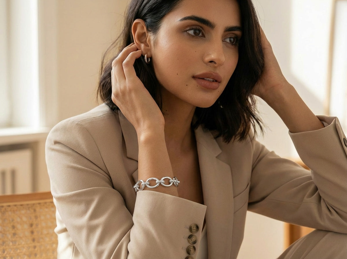 Woman wearing a silver bracelet in a neutral setting