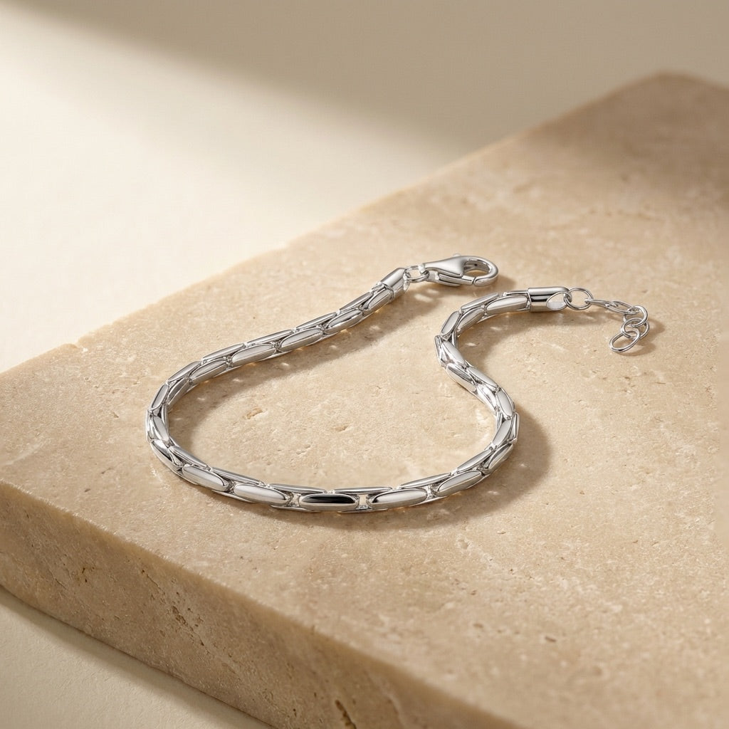 Silver bracelet on a beige stone surface