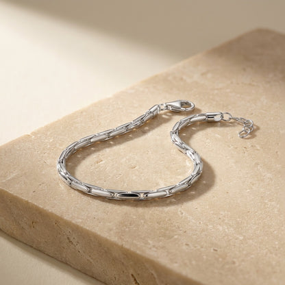 Silver bracelet on a beige stone surface