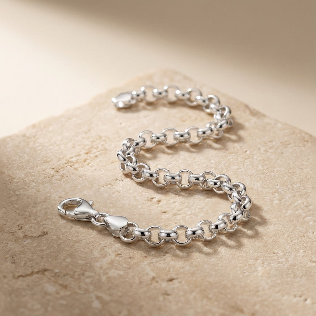 Silver chain bracelet on a beige stone surface