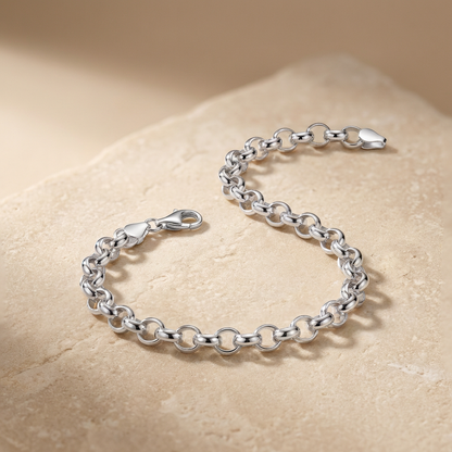 Silver chain bracelet on a beige stone surface
