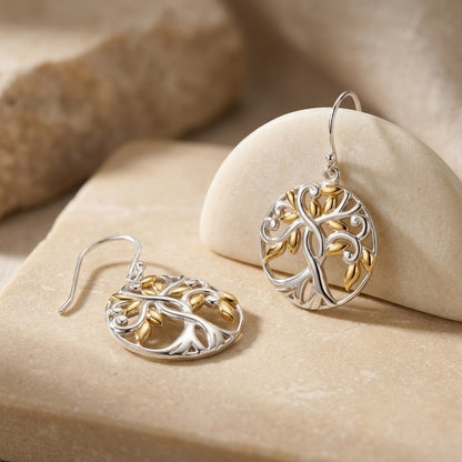 Pair of Tree of Life Gold plate Earrings  on a beige stone surface