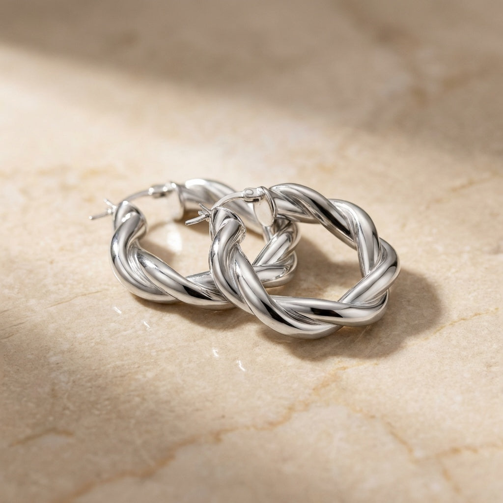 Silver hoop earrings on a beige marble surface