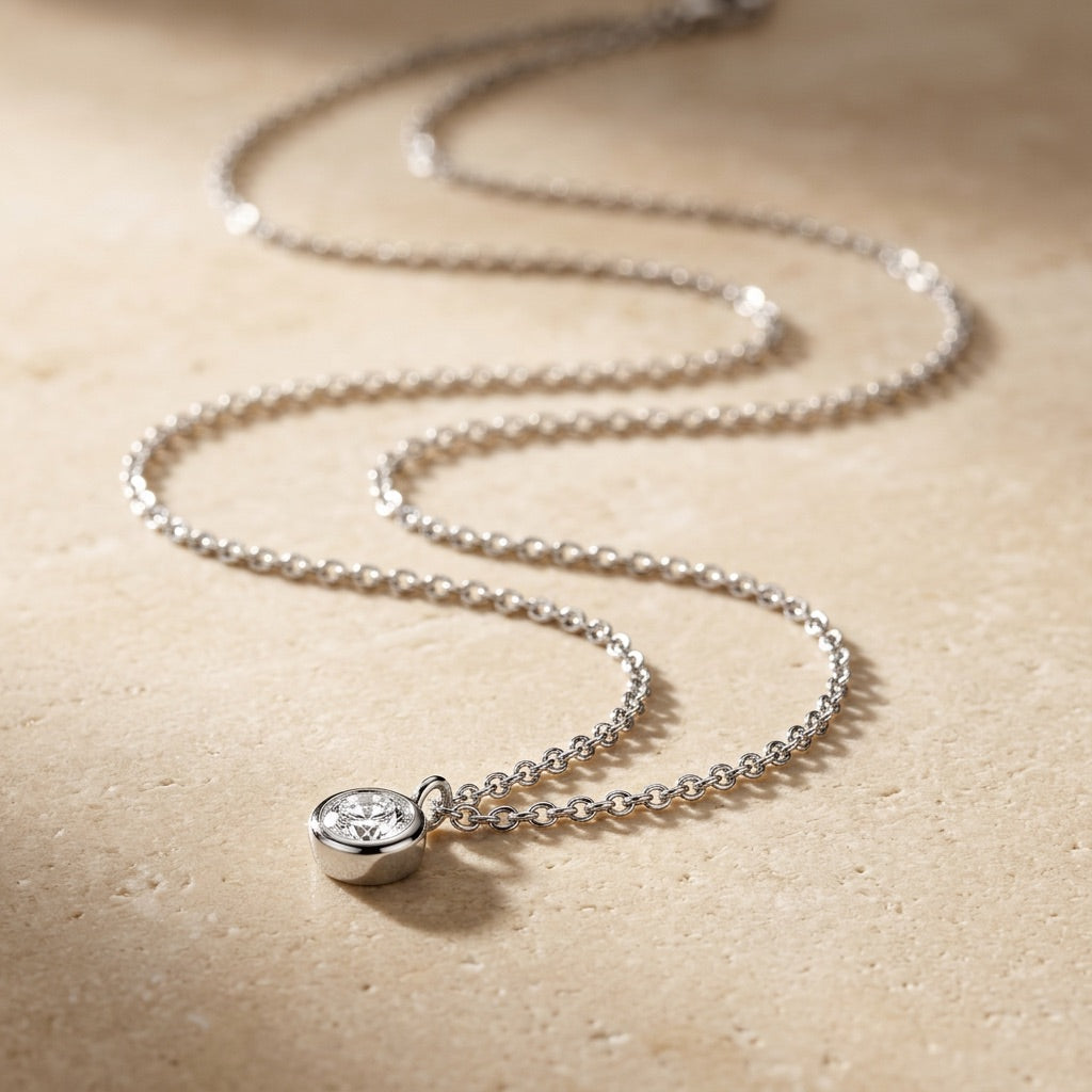 Silver necklace with a diamond pendant on a beige background