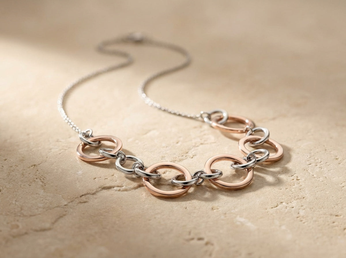 Necklace with interlocking rings on a beige stone surface