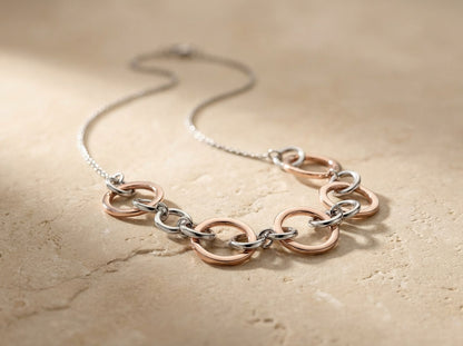 Necklace with interlocking rings on a beige stone surface