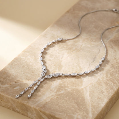 Cubic Zirconia Marquise Statement Necklace with clear stones on a beige stone surface