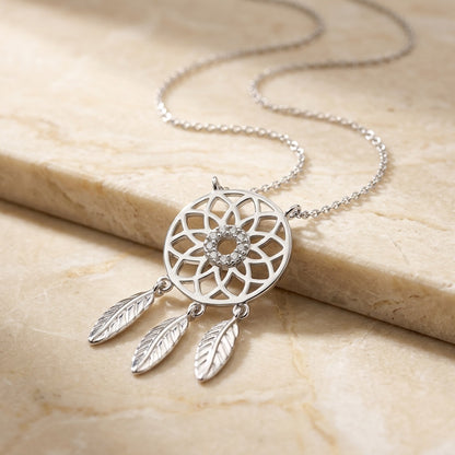 Dream Catcher with Cubic Zirconia necklace on a beige stone surface