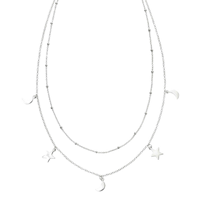 Layered silver necklace with star and moon pendants on a white background