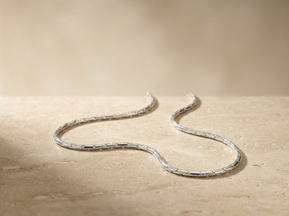 Silver chain necklace on a wooden surface