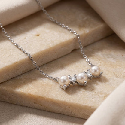 Curved Freshwater Pearl and Cubic Zirconia Bar Necklace on beige stone surface