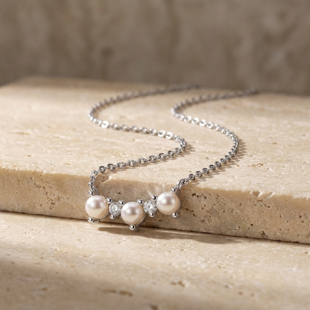 Curved Freshwater Pearl and Cubic Zirconia Bar Necklace with silver chain on a stone surface
