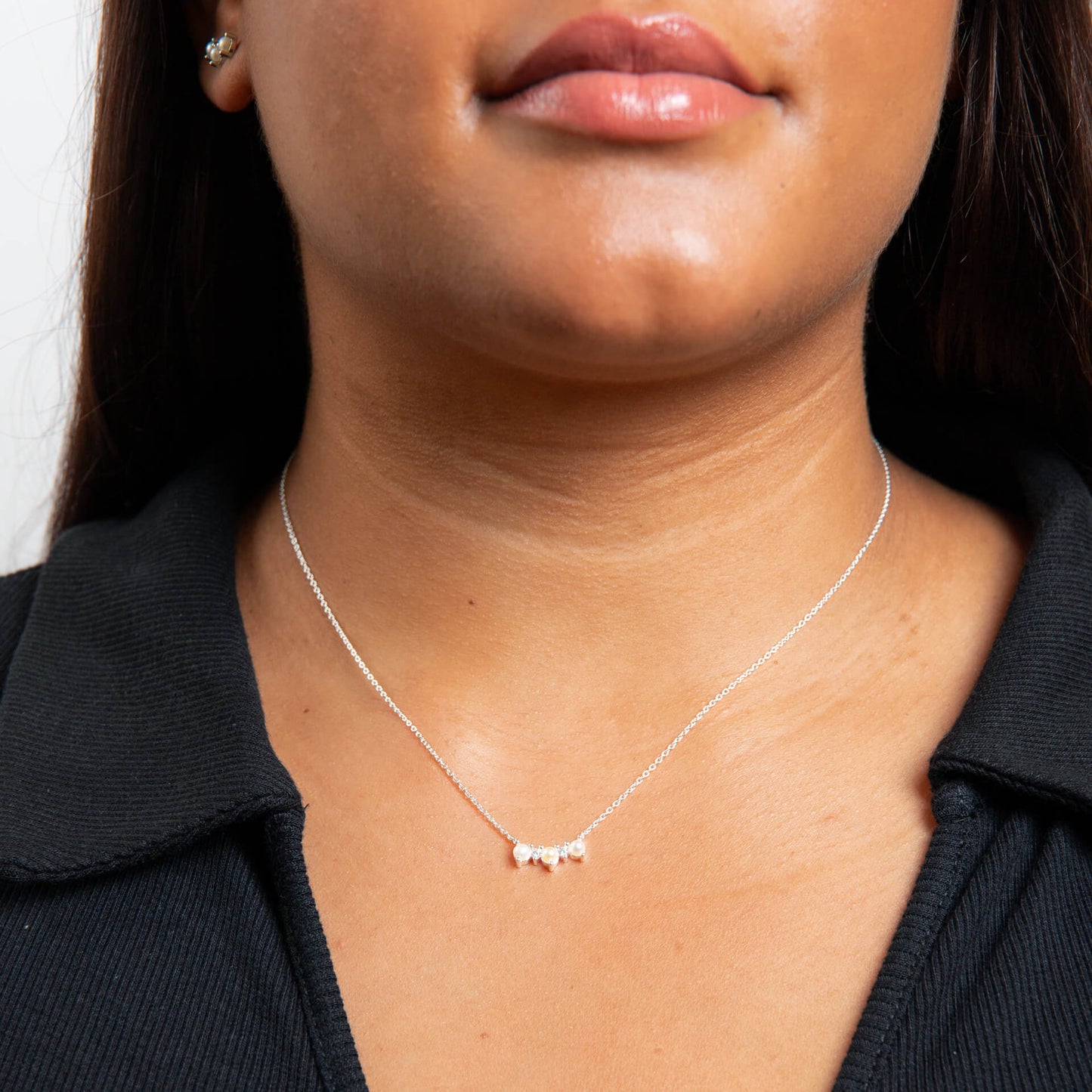 Close-up of a person wearing a delicate Curved Freshwater Pearl and Cubic Zirconia Bar Necklace