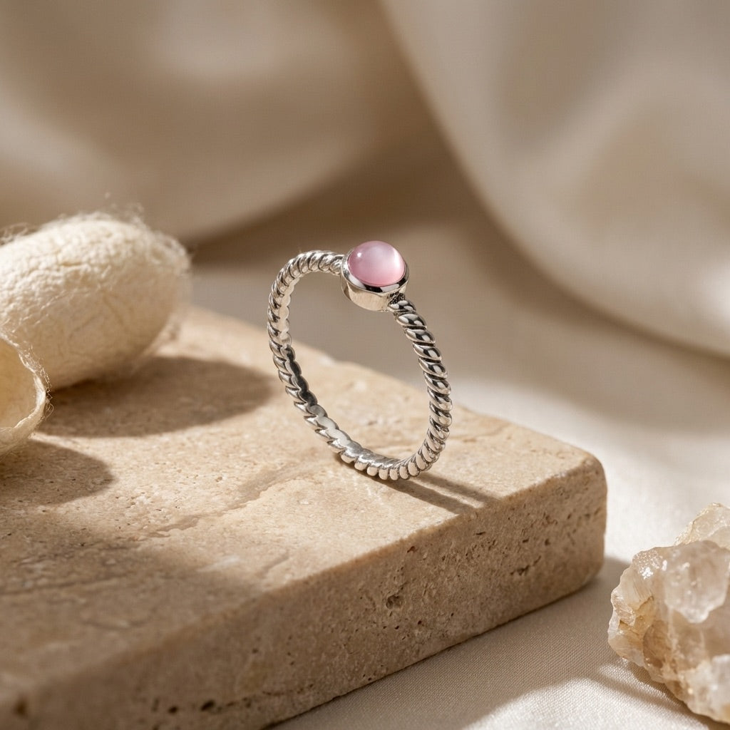 Twisted Pink Pearl Ring on a beige stone surface
