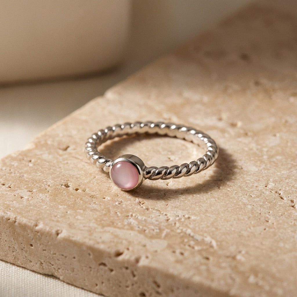 Twisted Pink Pearl Ring on a textured beige surface