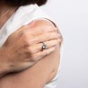 Close-up of a hand holding a diamond ring on a white background