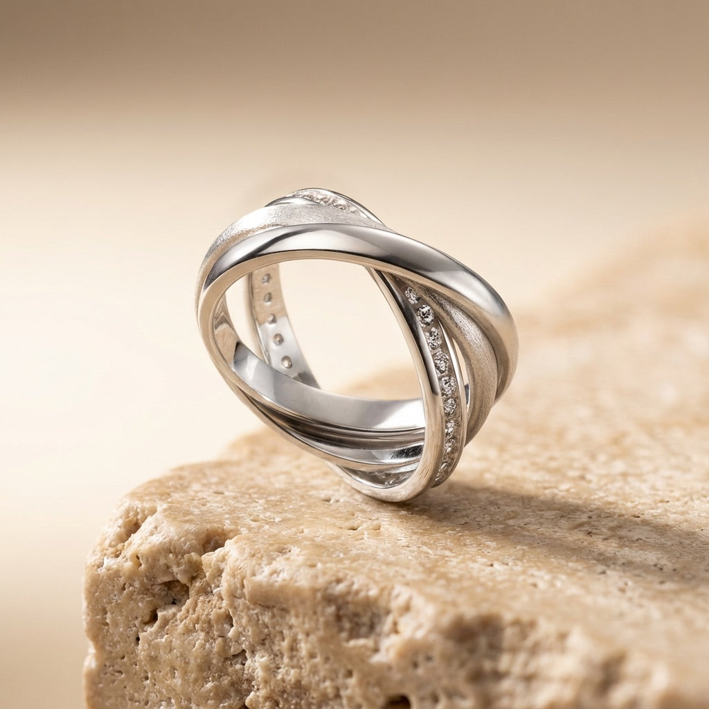 Silver ring with diamond accents on a beige stone surface
