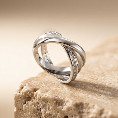 Silver ring with diamond accents on a beige stone surface