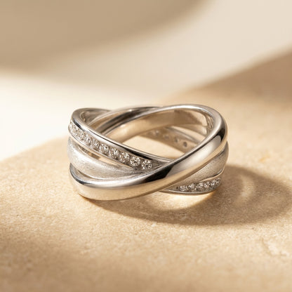 Silver ring with diamond accents on a beige background