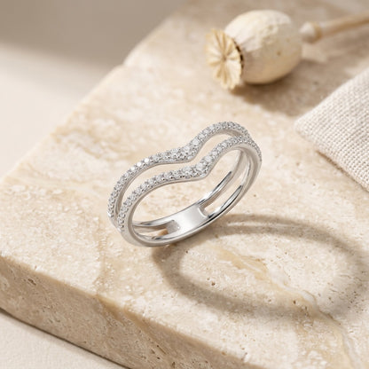 Silver ring with small diamonds on a textured beige surface
