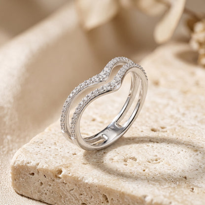 Silver ring with diamonds on a beige stone surface