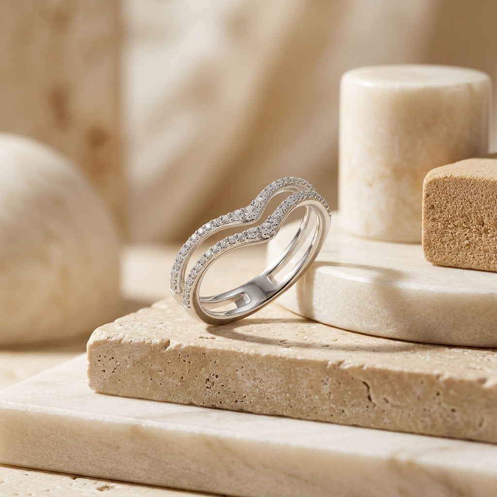 Silver ring with small diamonds on a beige stone surface