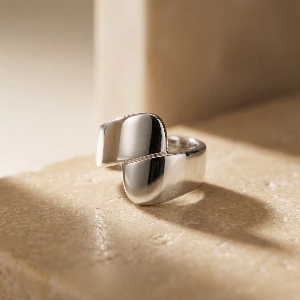 Silver Wrap Ring  on a beige surface with soft shadows