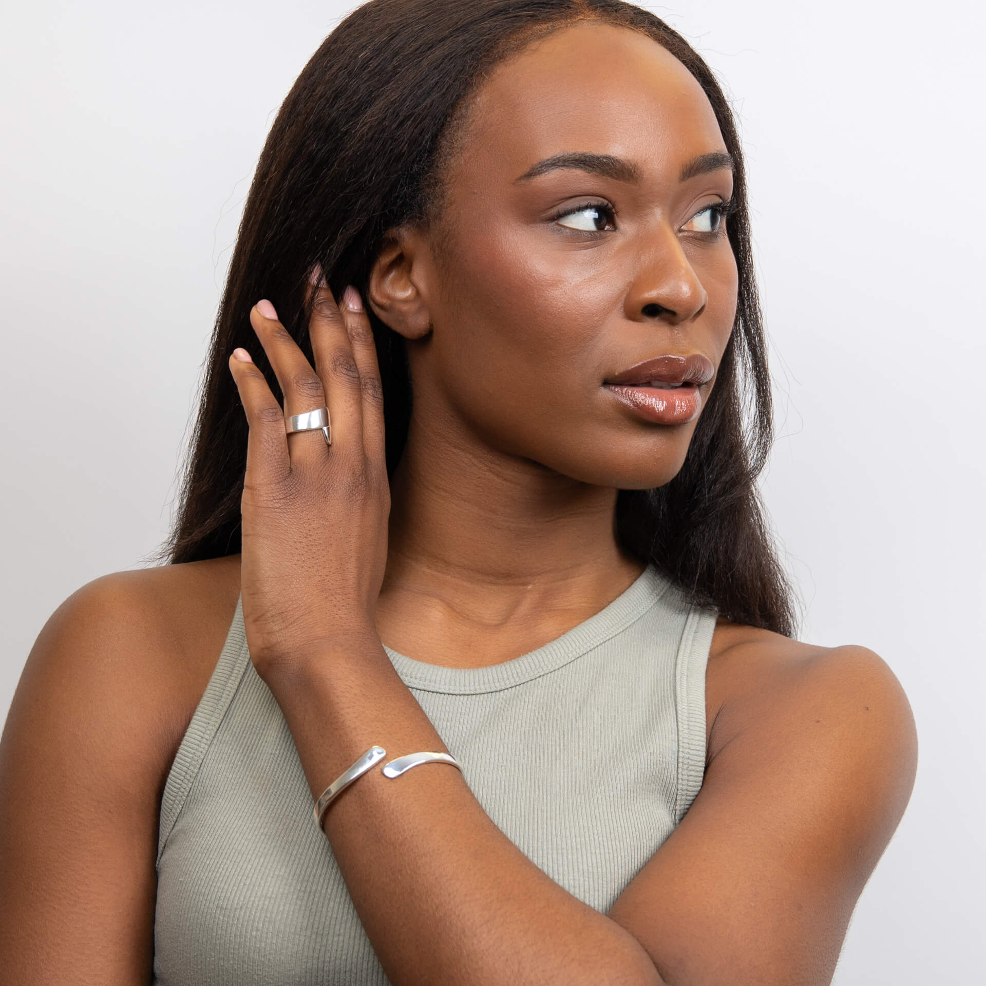 Woman wearing a Silver Wrap Ring and bracelet on a plain background